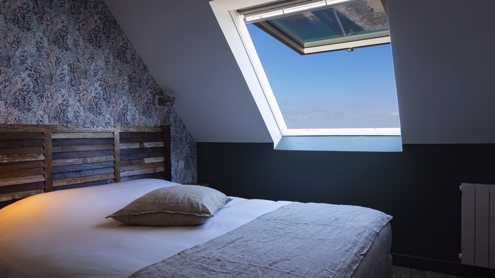 Chambre du deuxième étage avec fenêtre de toit et vue mer