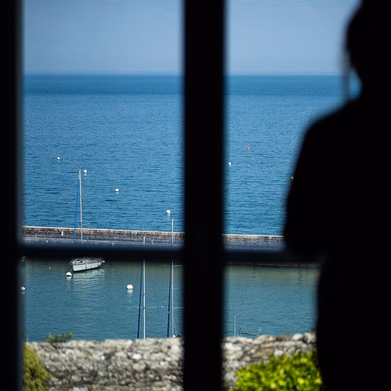 Mer et remparts vus à travers la fenêtre d’une chambre