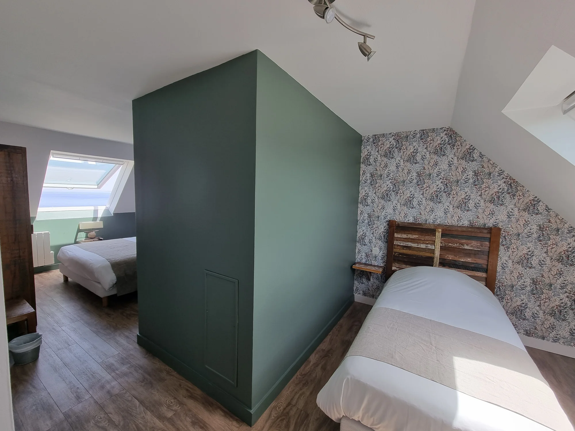 Chambre familiale vue mer de l’Hôtel Vauban, avec un lit double sous la fenêtre de toit et un lit simple