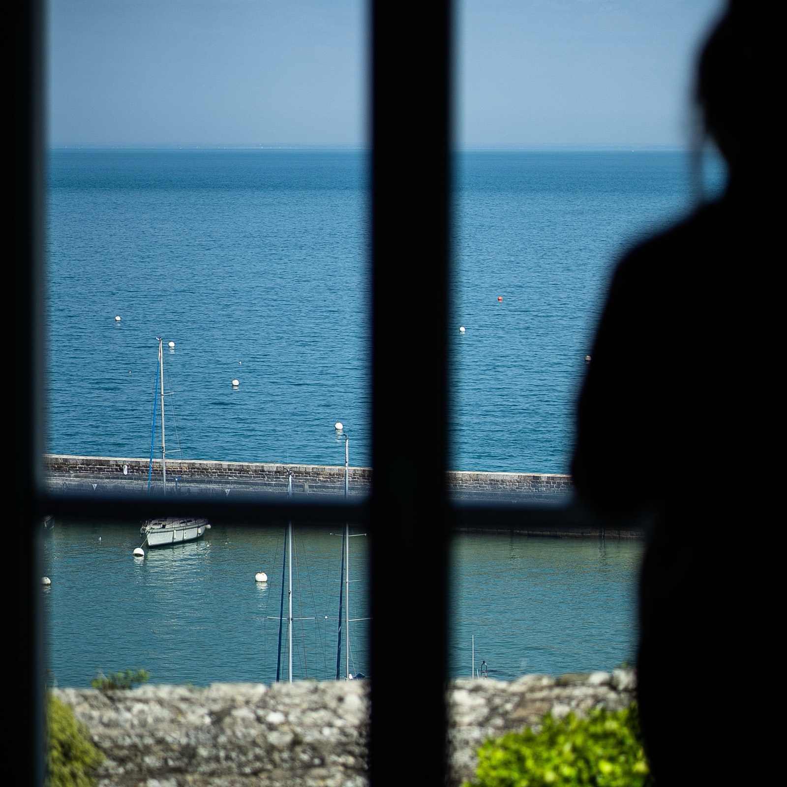 Mer et remparts vus à travers la fenêtre d’une chambre